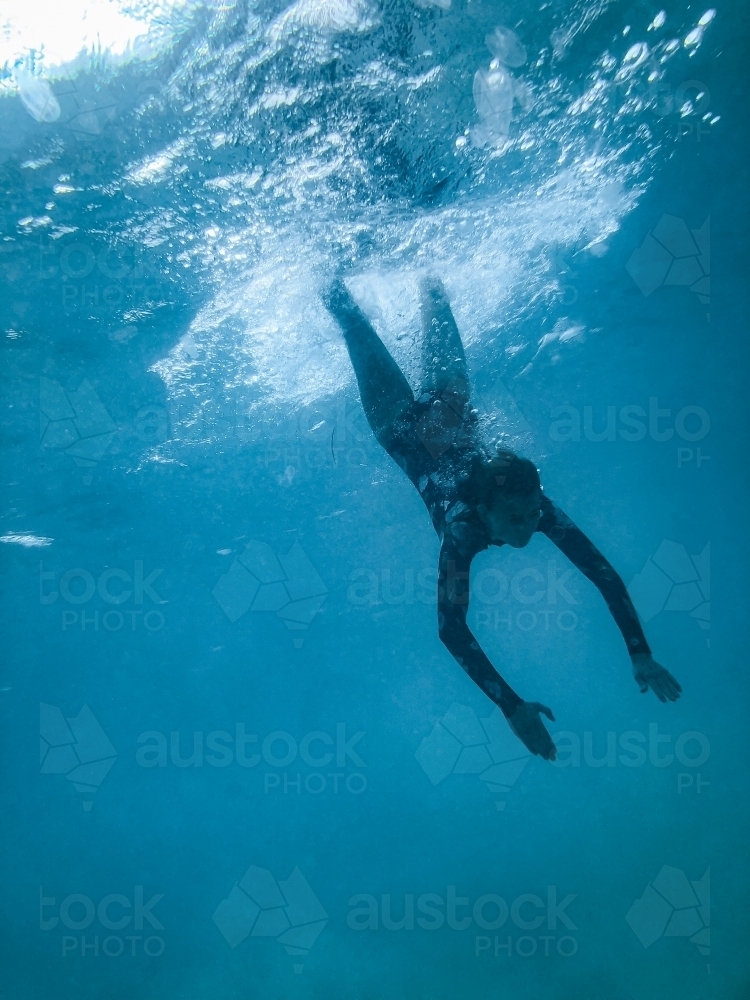 Image of Female underwater in ocean wearing full piece swimsuit