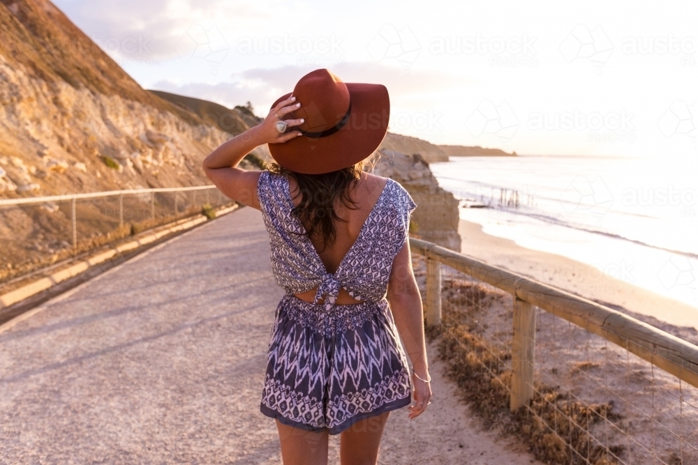 Female walks towards beach at sunset - Australian Stock Image