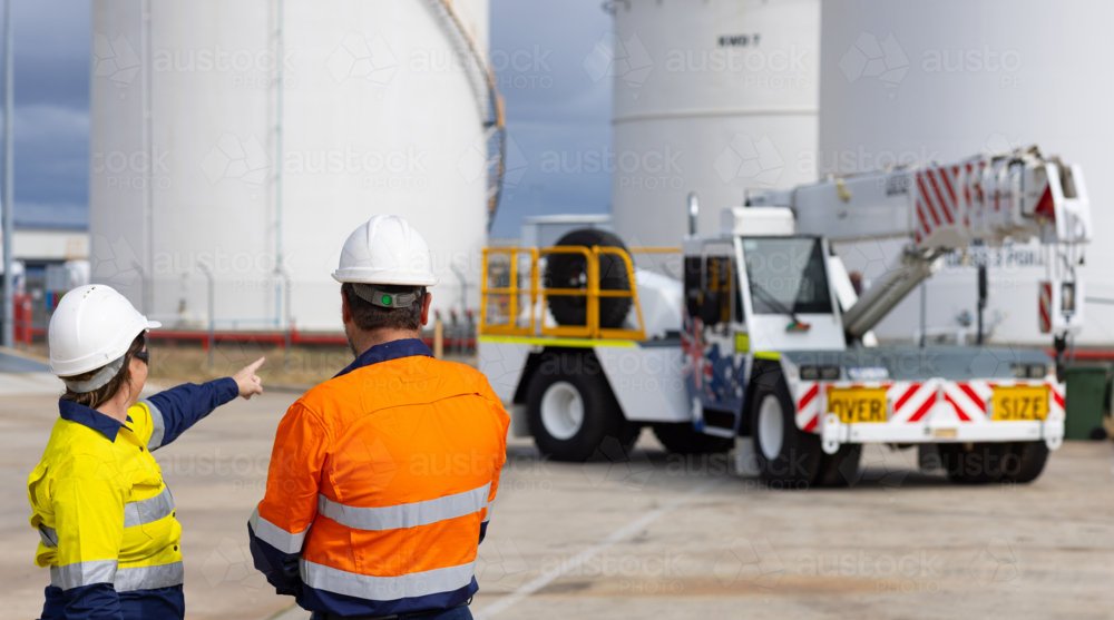 Female worker pointing at franna crane truck - Australian Stock Image