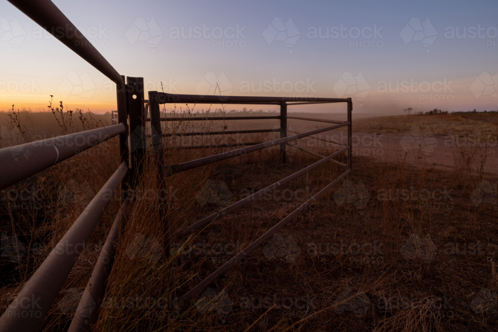 Fence and gates on cattle station, at sunrise - Australian Stock Image
