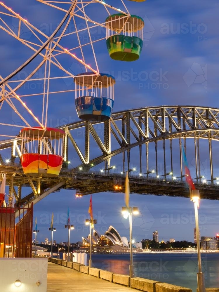 Ferris wheel cabs against a blue sky with Harbour Bridge in the background - Australian Stock Image