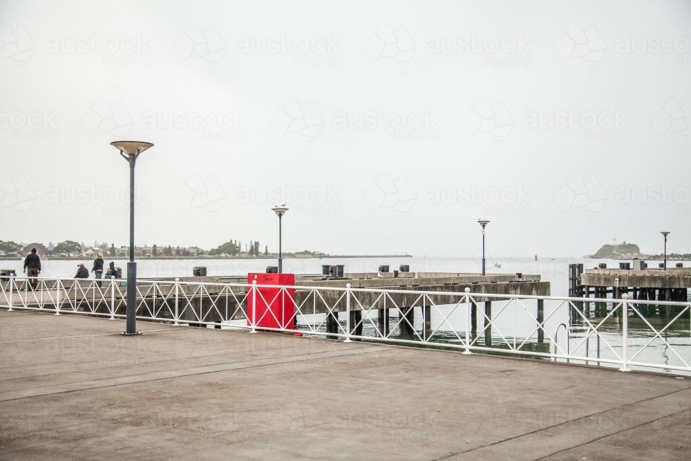 Ferry wharf in river mouth in Newcastle on overcast day - Australian Stock Image