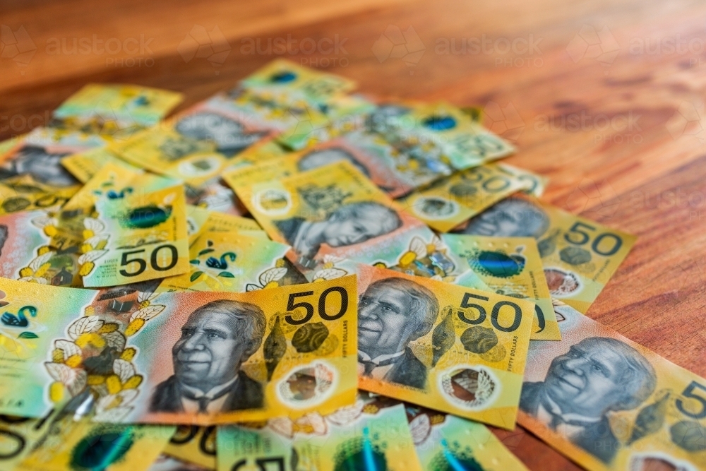 Fifty dollar australian bank notes for cash payment scatted on table - Australian Stock Image