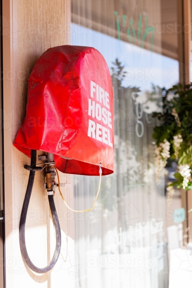 Fire hose reel with cover in urban setting - Australian Stock Image