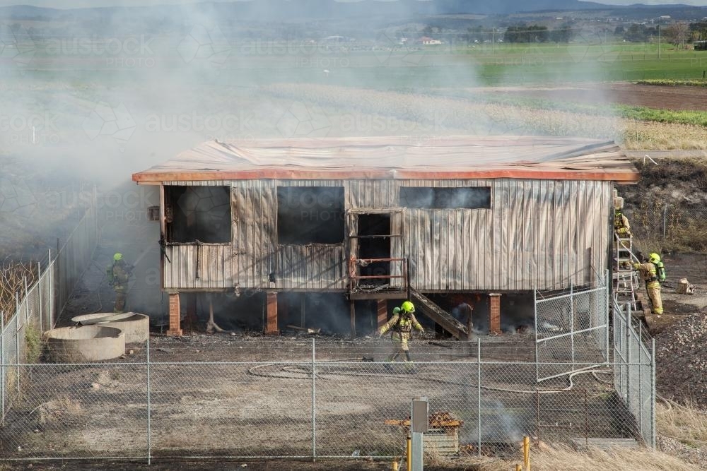 Firefighters around a burnt out shed - Australian Stock Image