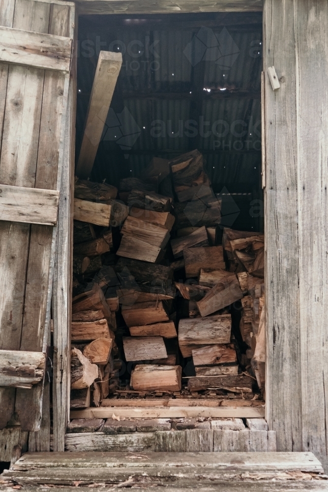 Firewood stacked in the shed. - Australian Stock Image
