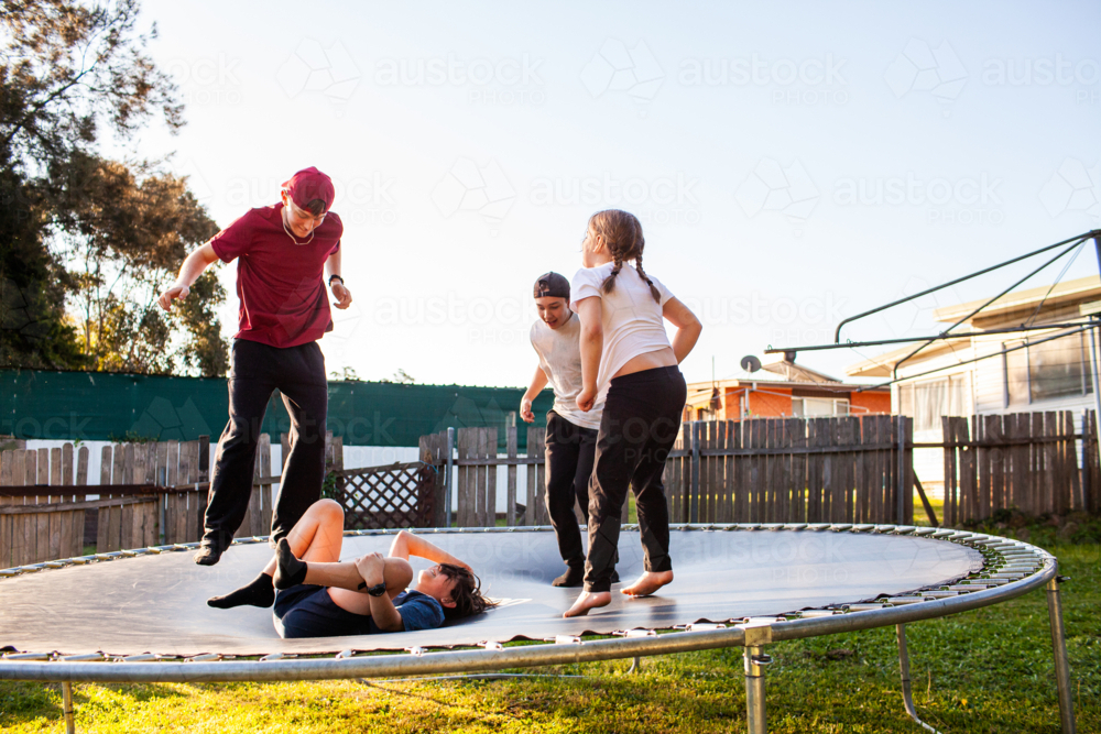 First Nations Australian Kids playing crack the egg on trampoline in backyard : Austockphoto First Nations Australian Kids playing crack the egg on trampoline in backyard - Australian Stock Image