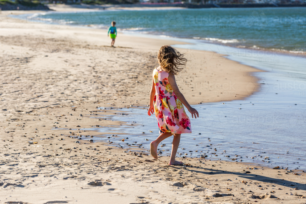 First Nations Australian Torres Strait Island girl playing by the water on windy day at the beach - Australian Stock Image