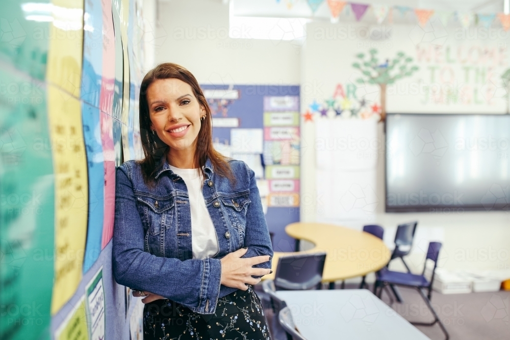 First Nations public school teacher smiling at the camera in classroom - Australian Stock Image
