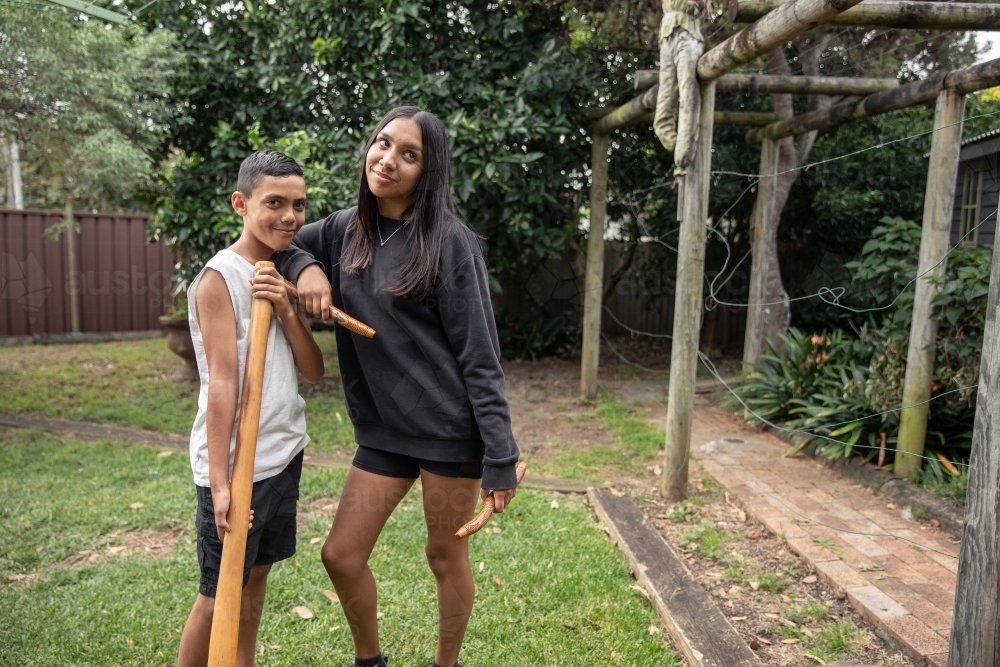 First Nations teenagers holding Indigenous instruments - Australian Stock Image