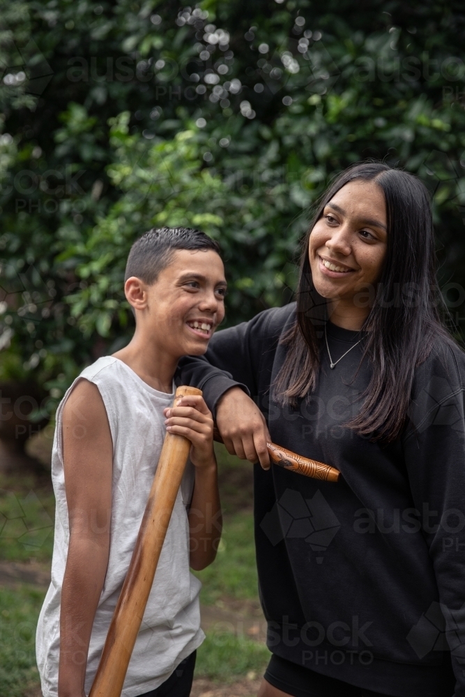 First Nations teenagers holding Indigenous instruments - Australian Stock Image