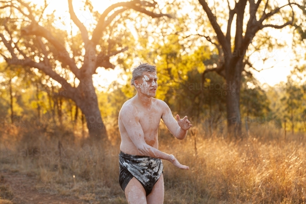 First Nations young man clapping and singing song for storytelling dance - Australian Stock Image