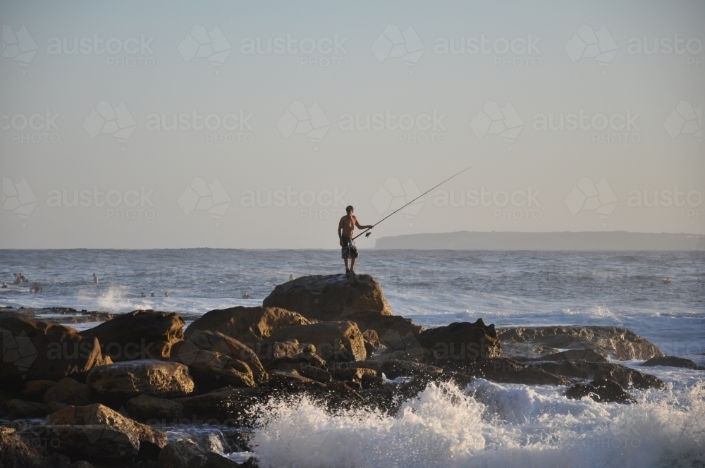 Fisherman on rocks - Australian Stock Image