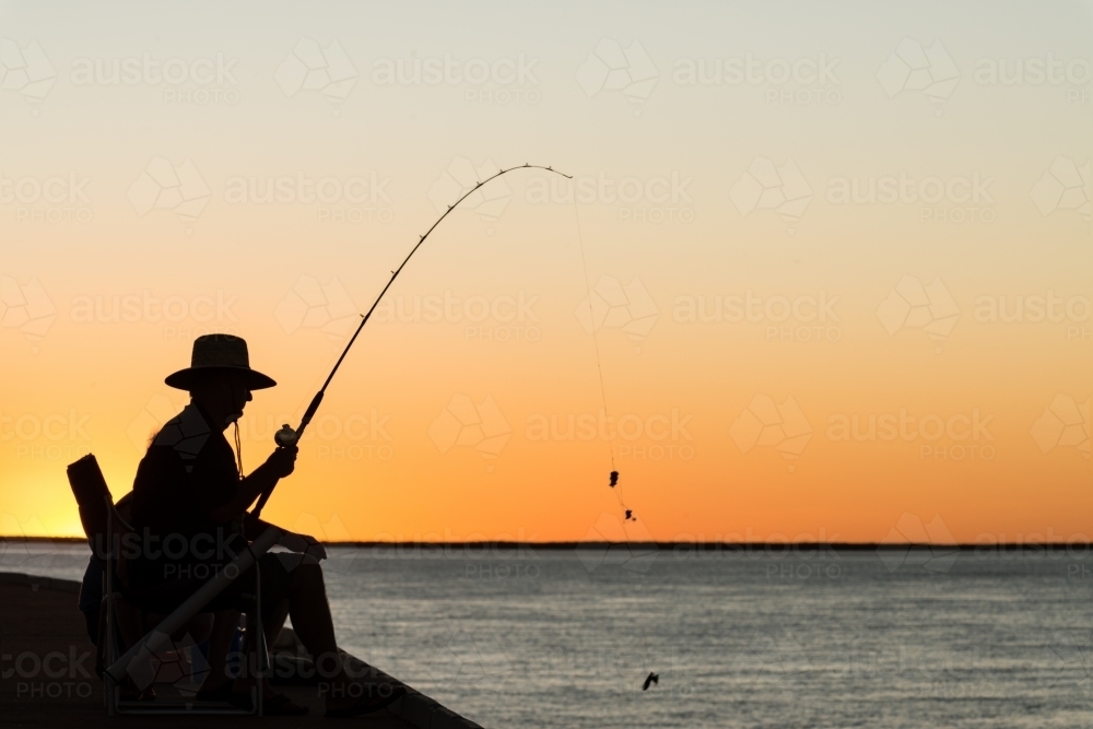 Fisherman silhouetted in the sunset - Australian Stock Image
