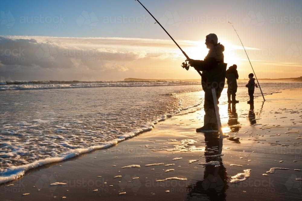 Fishermen on the beach at sunset - Australian Stock Image