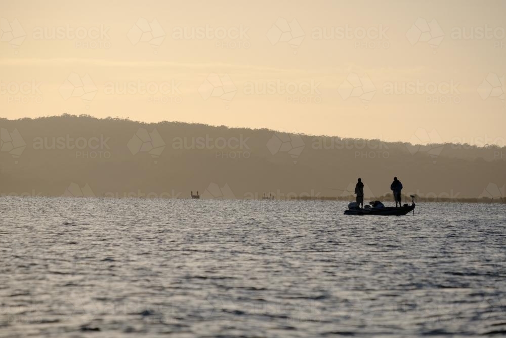 Fishermen standing in a Boat on Mallacoota Inlet - Australian Stock Image