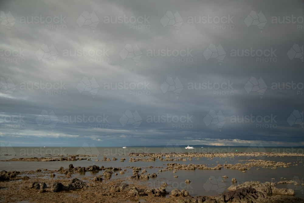 Fishing boats in the bay off Redcliffe in Brisbane's northern suburbs on overcast day - Australian Stock Image