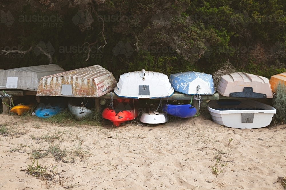 Fishing boats stacked on dry land on a beach at mornington - Australian Stock Image
