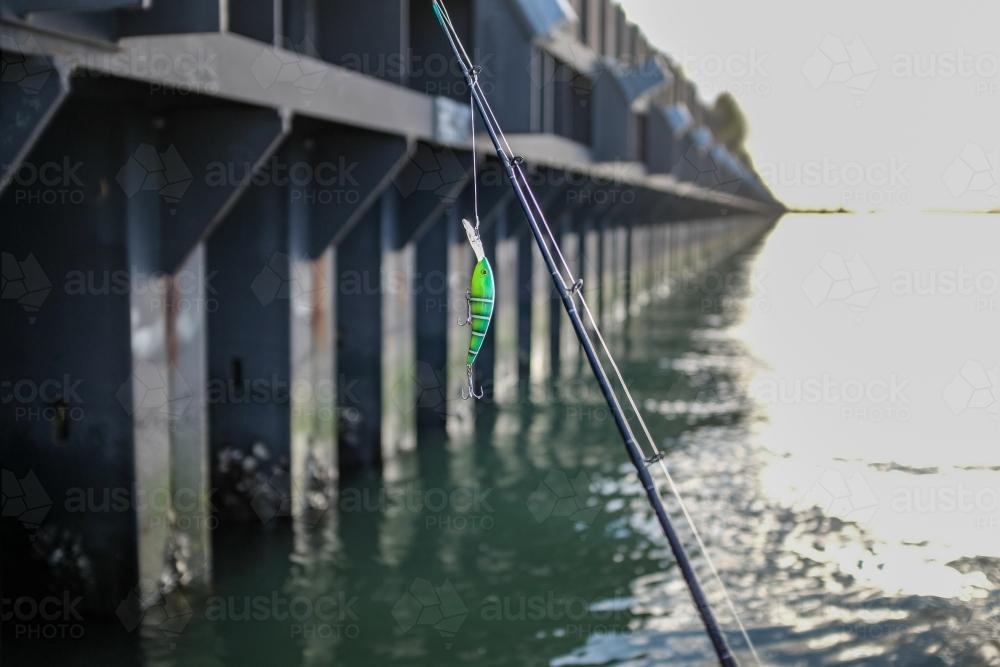 Fishing lure hanging from fishing rod - Australian Stock Image