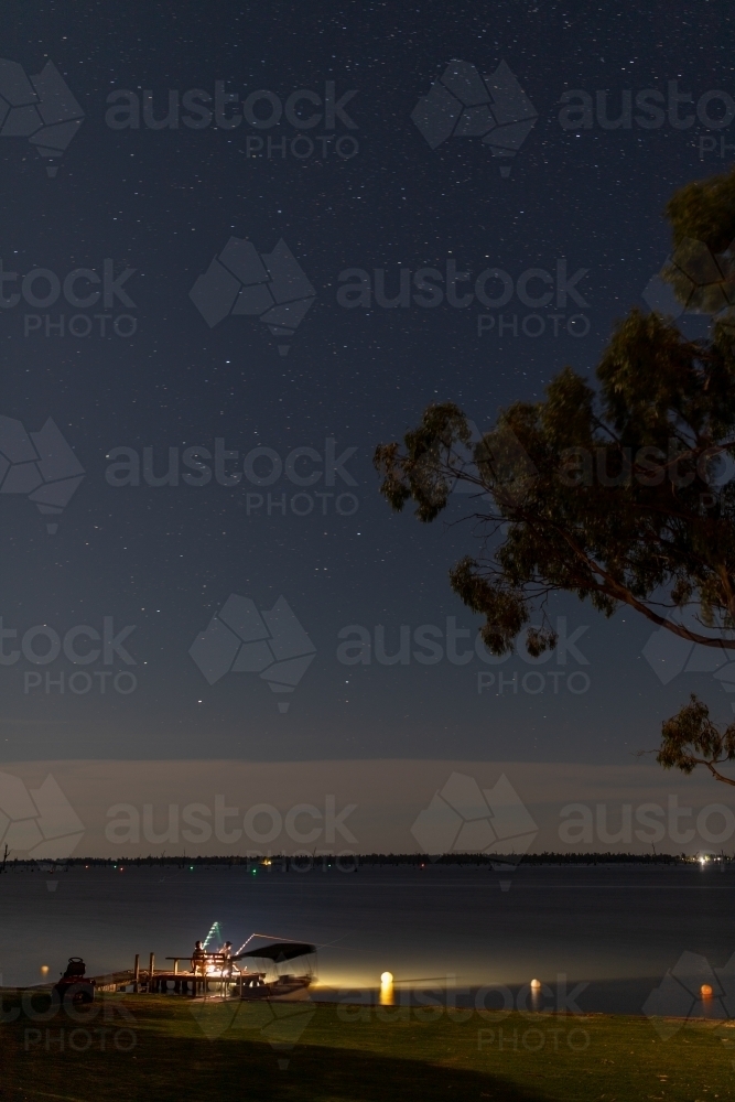 Fishing rod lights on lake jetty at night - Australian Stock Image