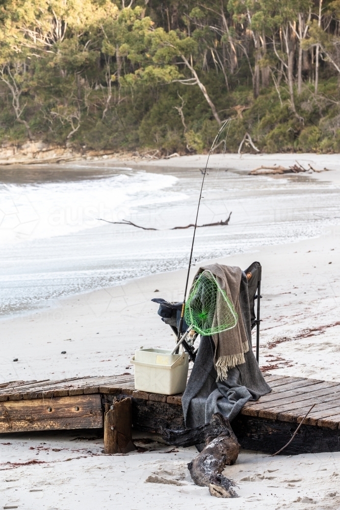 Fishing supplies on a fold-out chair on the beach - Australian Stock Image