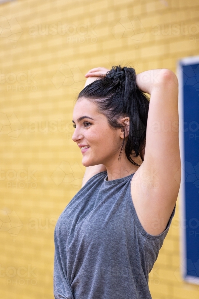 fit girl doing stretching exercise before playing sport - Australian Stock Image
