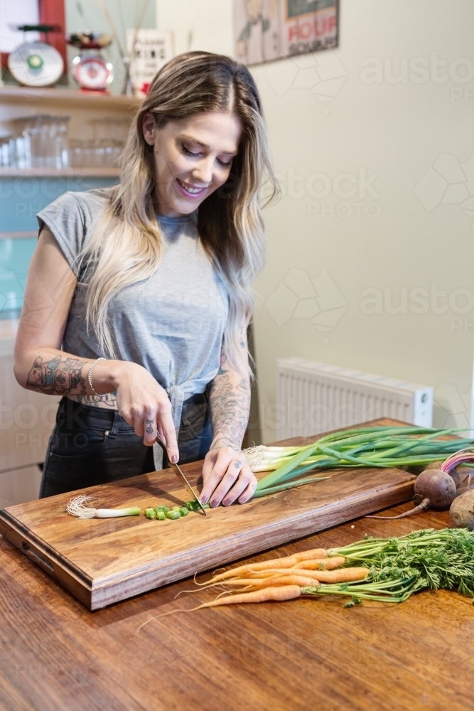 Fit healthy girl making vegetarian dinner at home - Australian Stock Image