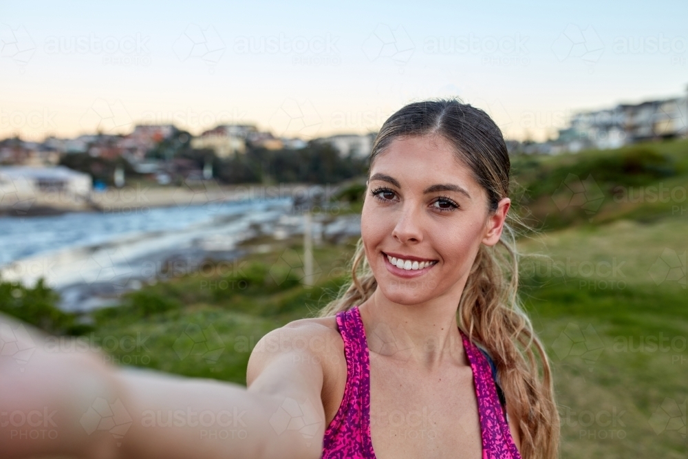 Fitness woman taking a selfie at coastal headland - Australian Stock Image