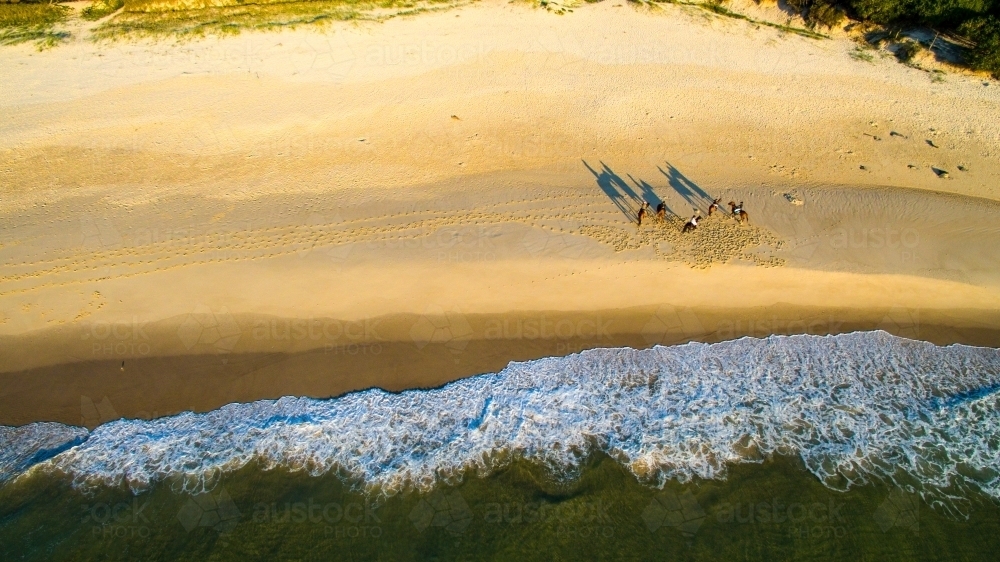 Five women riding horses on the sand along Maggies Beach at Cabarita Beach - Australian Stock Image