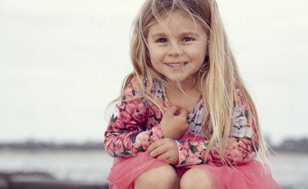 Five year old sitting smiling at camera - Australian Stock Image