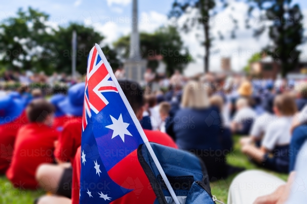 flag detail during ANZAC Day ceremony at park with crowds of people - Australian Stock Image
