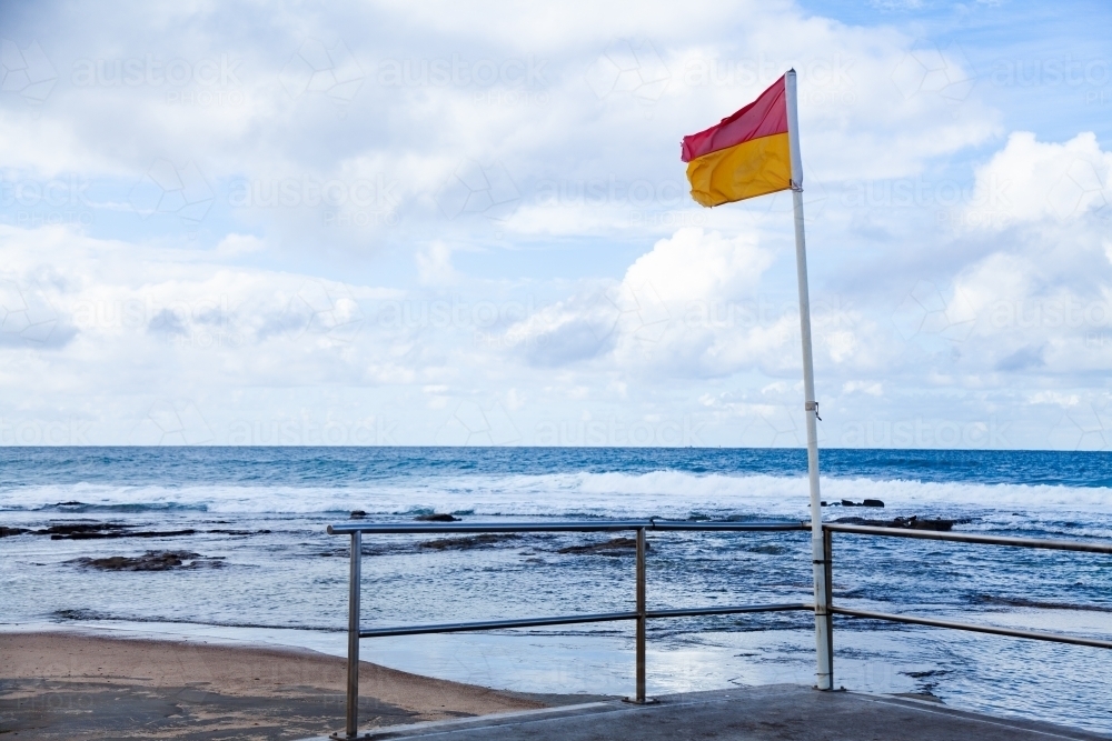 flag secured to railings at beach - Australian Stock Image