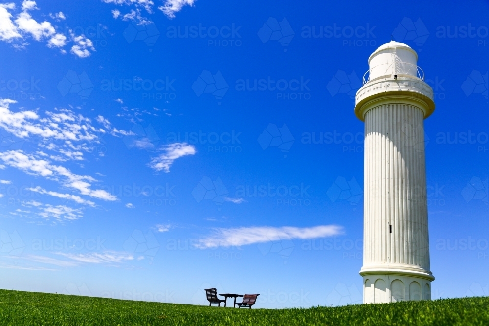 Flagstaff Hill Lighthouse, two benches and a table under a summer sky at Wollongong, NSW - Australian Stock Image