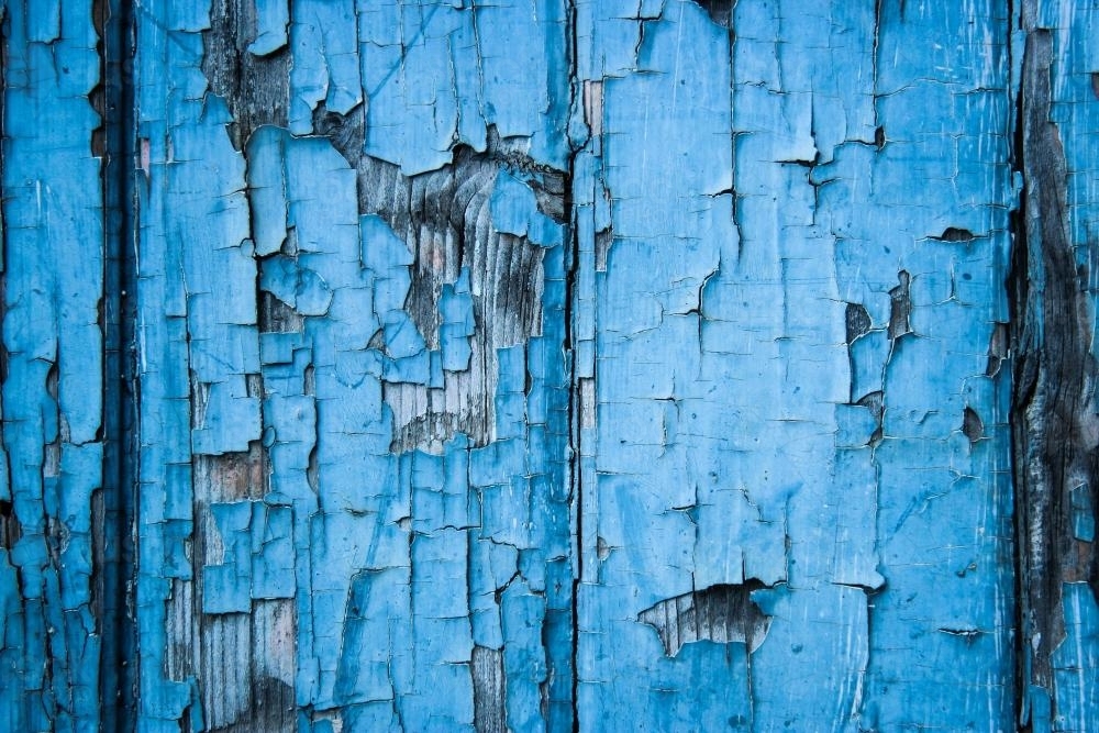 Image of Flaking blue paint peeling off wood textured door
