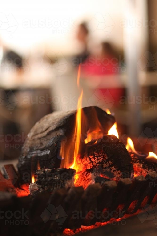 Flames burning logs in open fireplace in the snow - Australian Stock Image