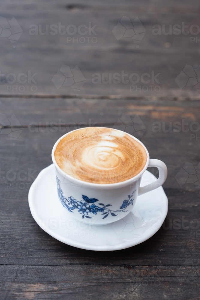 flat white coffee in a vintage teacup, on a dark wooden background - Australian Stock Image