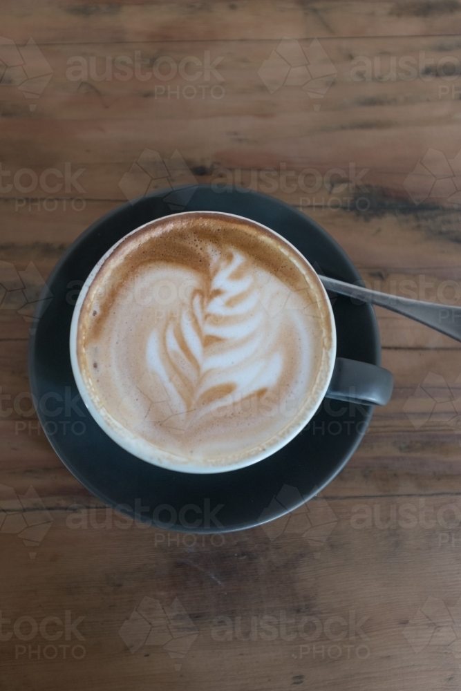 Flat white coffee on a wooden table - Australian Stock Image