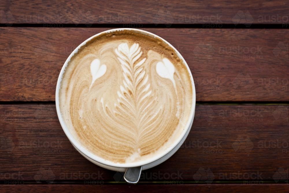Flat white coffee with latte art featuring hearts and rosetta - Australian Stock Image