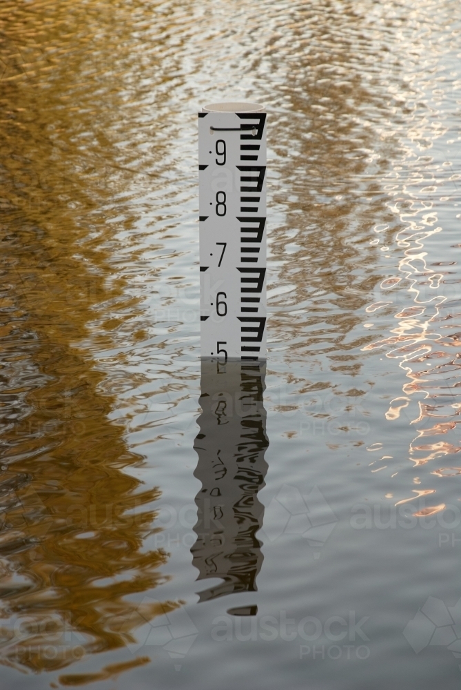 Flood depth marker in deep water in a flood zone. - Australian Stock Image