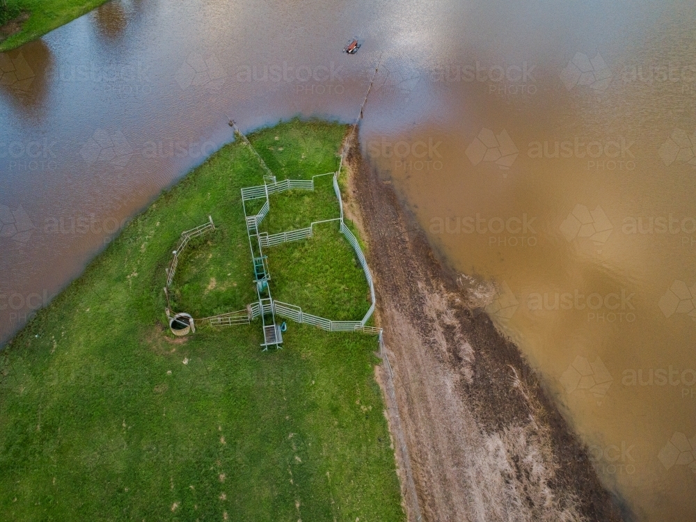 Flood waters creeping up towards cattle yard on farm - Australian Stock Image