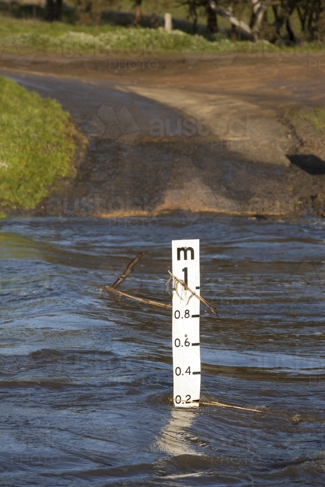 Flooded causeway and water level marker - Australian Stock Image