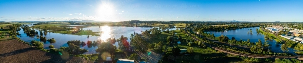 Flooded farm land, netball courts and park beside overflowing river with water levels rising up - Australian Stock Image