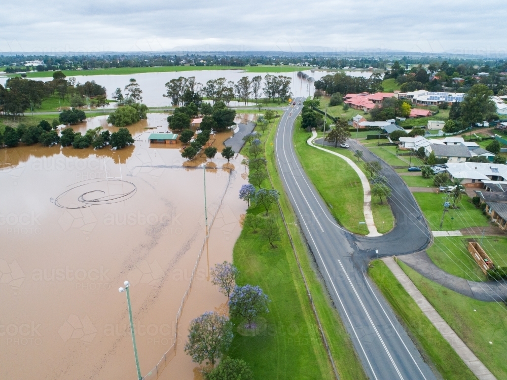 Flooded sports oval covered in brown floodwater - Australian Stock Image