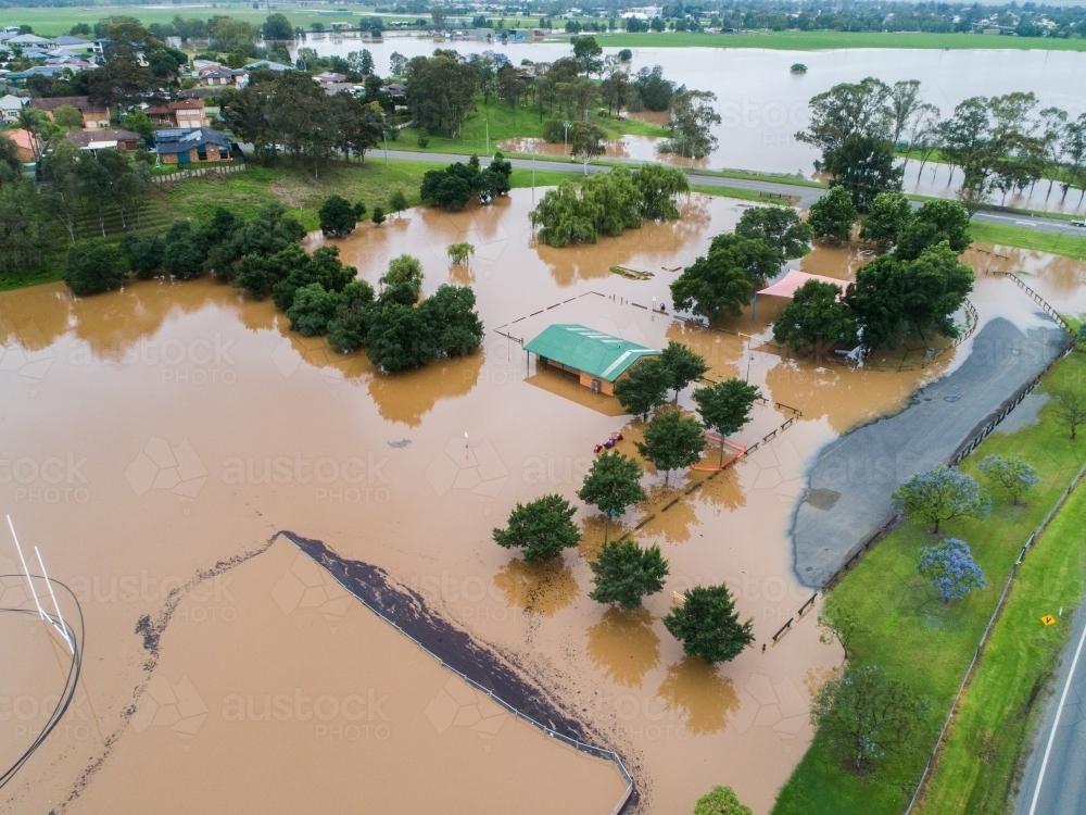 Flooded sports oval covered in brown floodwater - Australian Stock Image
