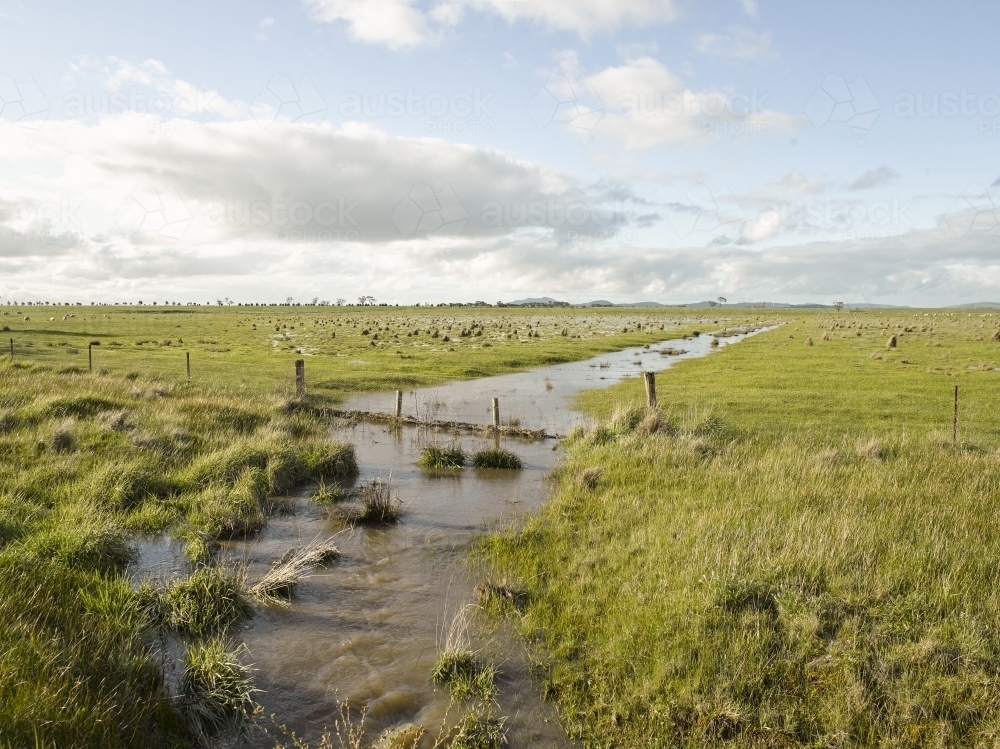 Floodwaters and fence line on paddock - Australian Stock Image