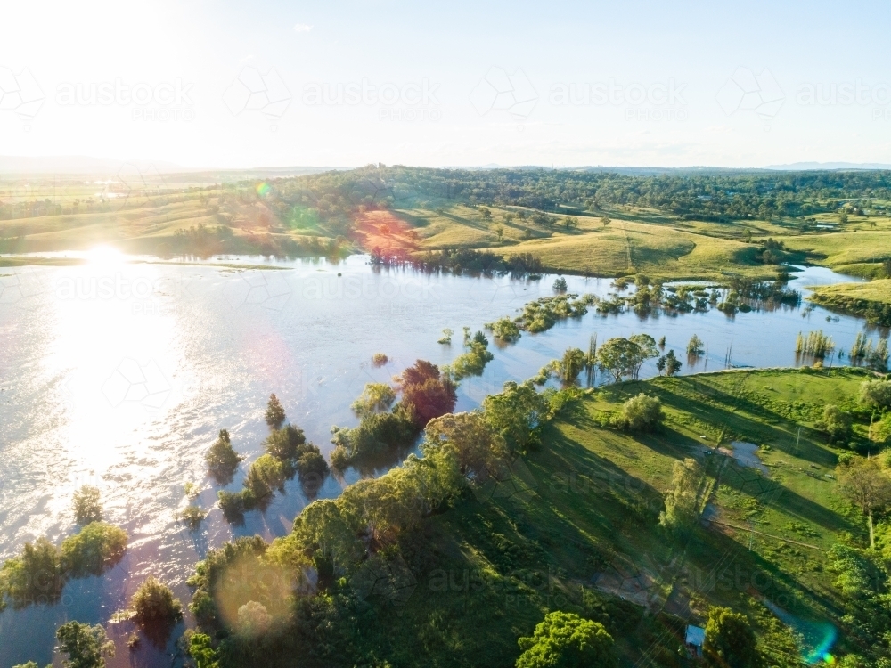 Floodwaters of river rising up and flooding over farmland - Australian Stock Image