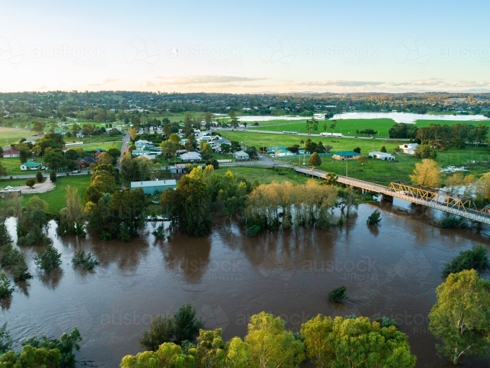 Image of Floodwaters of river rising up towards houses and bridge ...