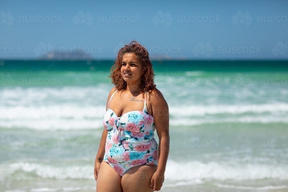 floral one-piece swimsuit on lady at the beach - Australian Stock Image