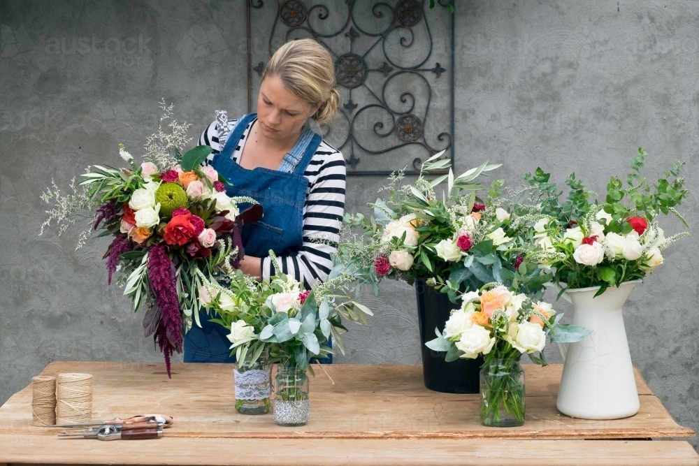 Florist at work on beautiful bunches of blooms - Australian Stock Image