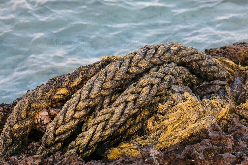 Flotsam and Jetstam, a thick yellow rope washed up on the beach - Australian Stock Image